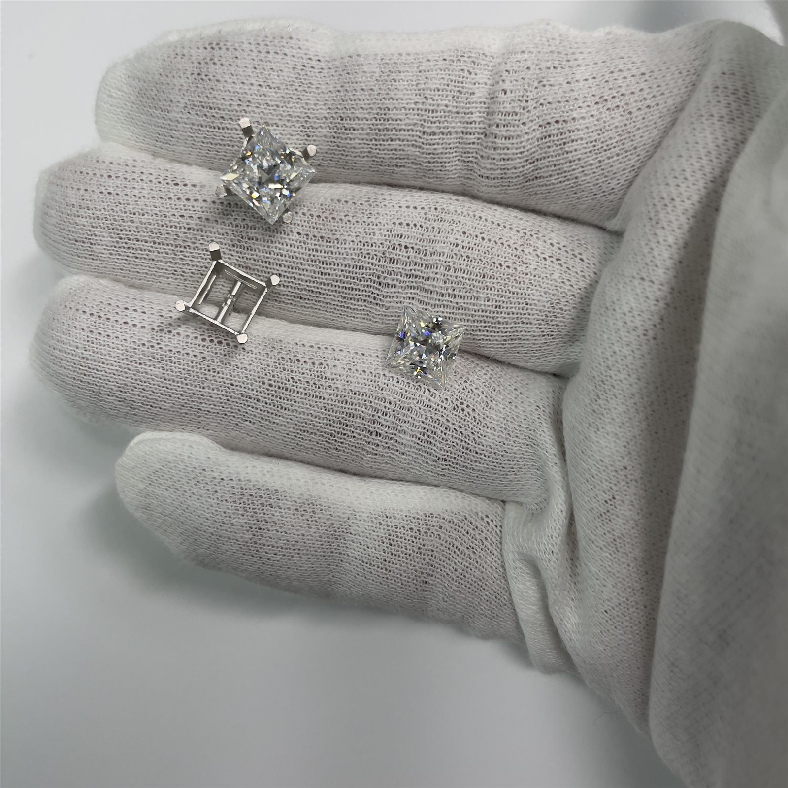 Diamond stud earrings being prepared by hand