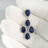 Heat treated blue sapphire, natural round brilliant diamond, halo set, dangling earrings, white gold